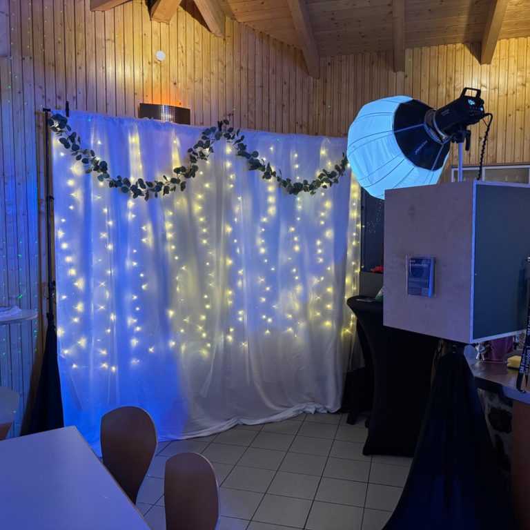 fotobox 30. geburtstag dekorierter hintergrund mit lichterketten und einer fotobox in einem festlichen raum.